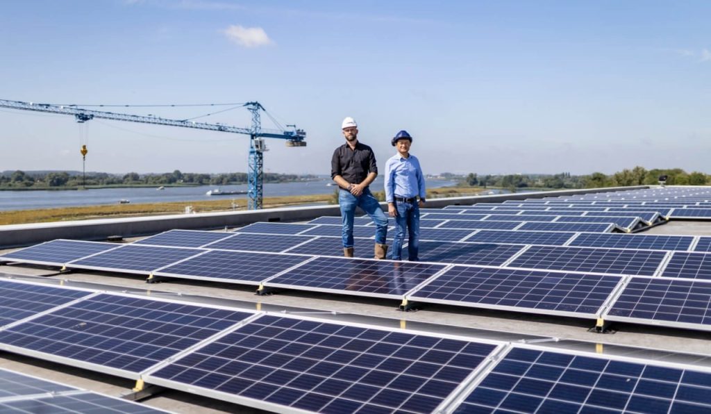 Два человека на солнечной электростанции — инженеры или менеджеры обсуждают проект, символизируя профессиональный подход и командную работу.